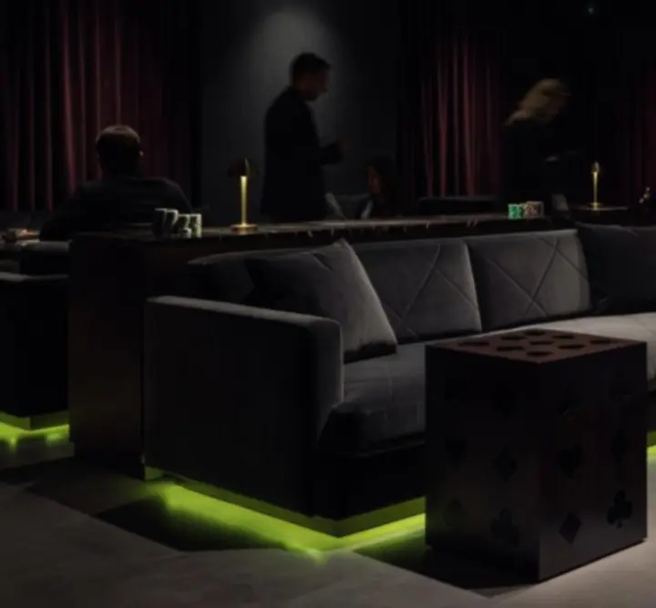Hangulatos, sötét lounge tér limezöld fényekkel és poker-inspirált részletekkel